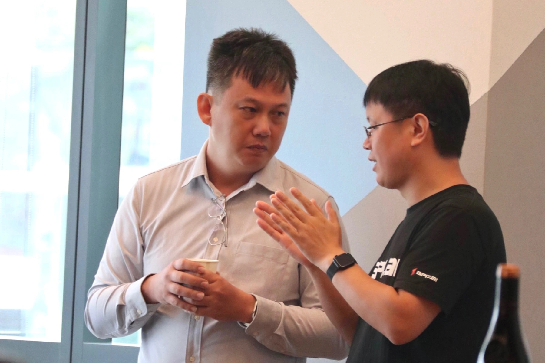 Yuansheng (on the right) is discussing technical details with the audience